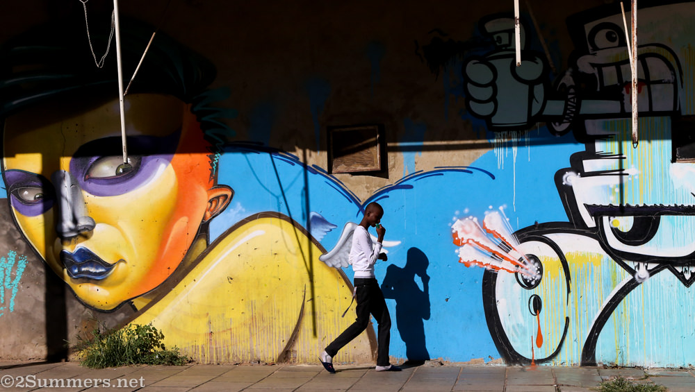 A passerby walks past a graffiti mural in Jeppestown.