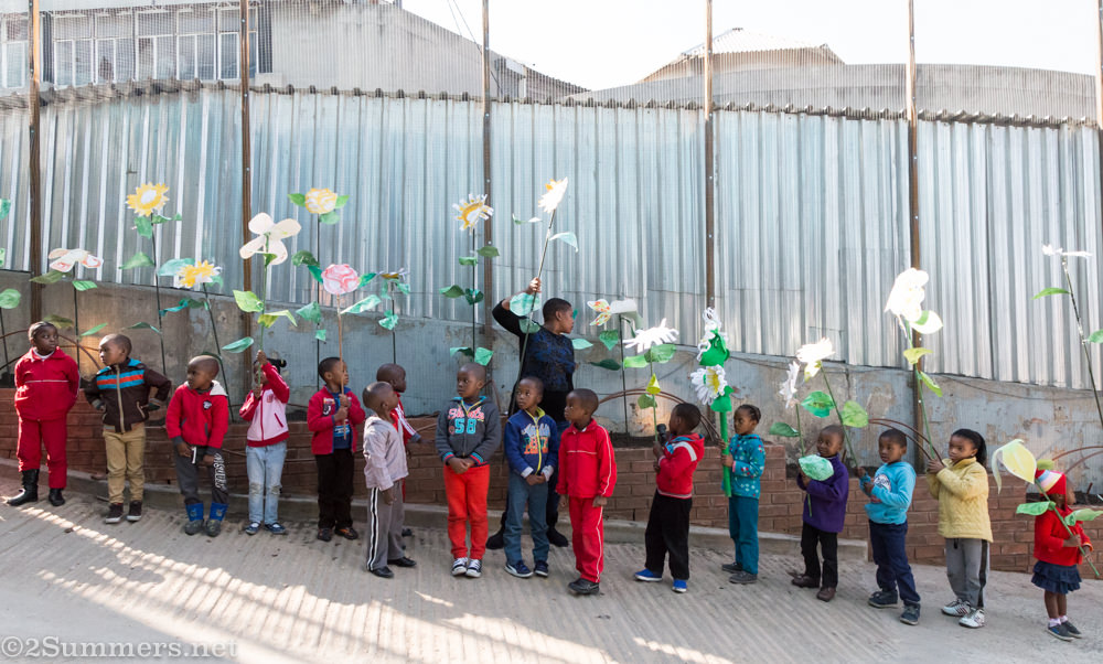 Line of children with flowers at Joziburg Lane