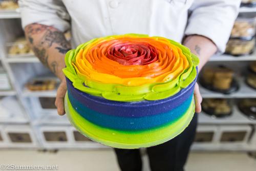 Chef Martin holding a rainbow cake at Café Patisse