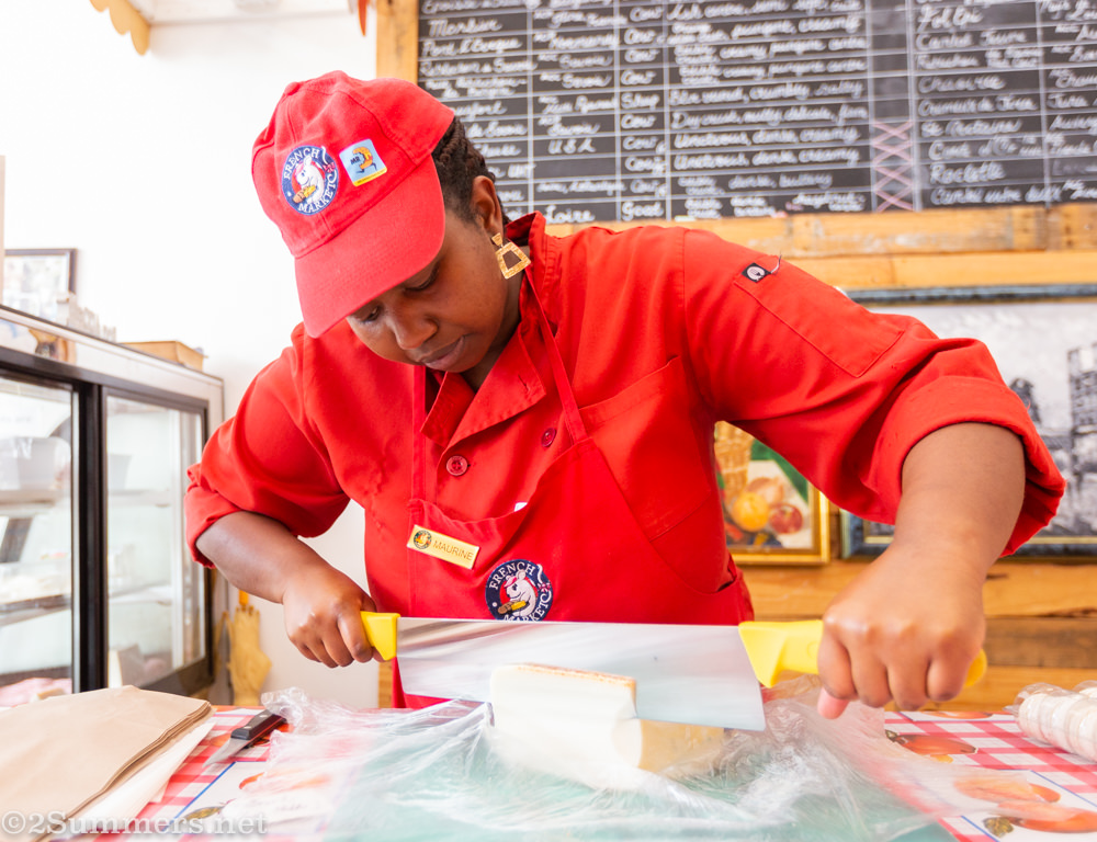 Maurine slicing cheese at Patisserie de Paris