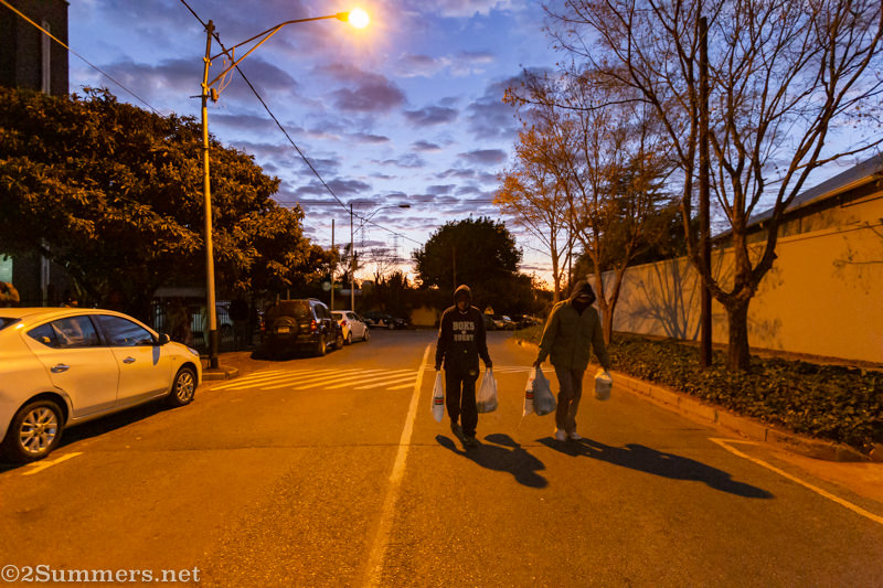 Guys leaving the church with their food parcels before sunrise
