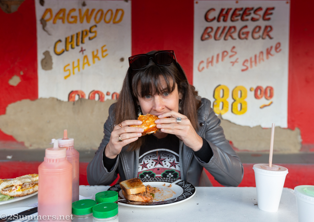 Heather eating at toasted sandwich at Pure and Cool roadhouse, Malvern