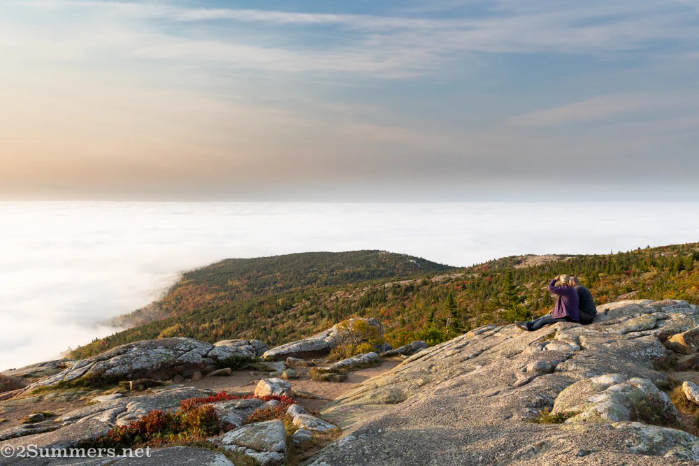 People looking out at the view from the summit of Cadillac Mountain